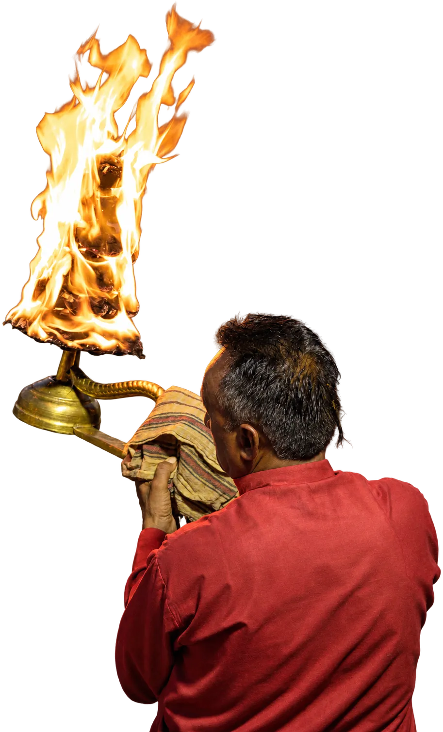 A man raising a flaming aarti lamp over the Ganga at Haridwar
