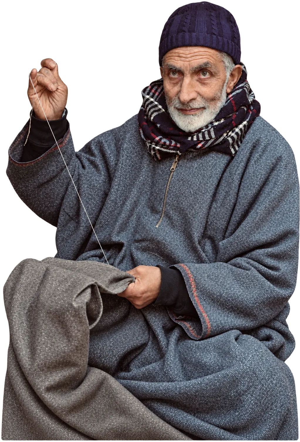 An elderly tailor in a woollen pheran, sewing by hand, Srinagar