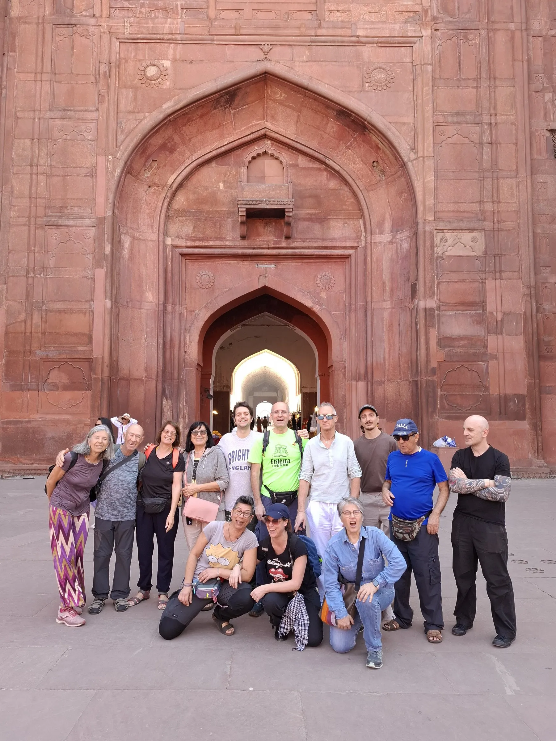 A group of travellers under the red sandstone gate of the Red Fort