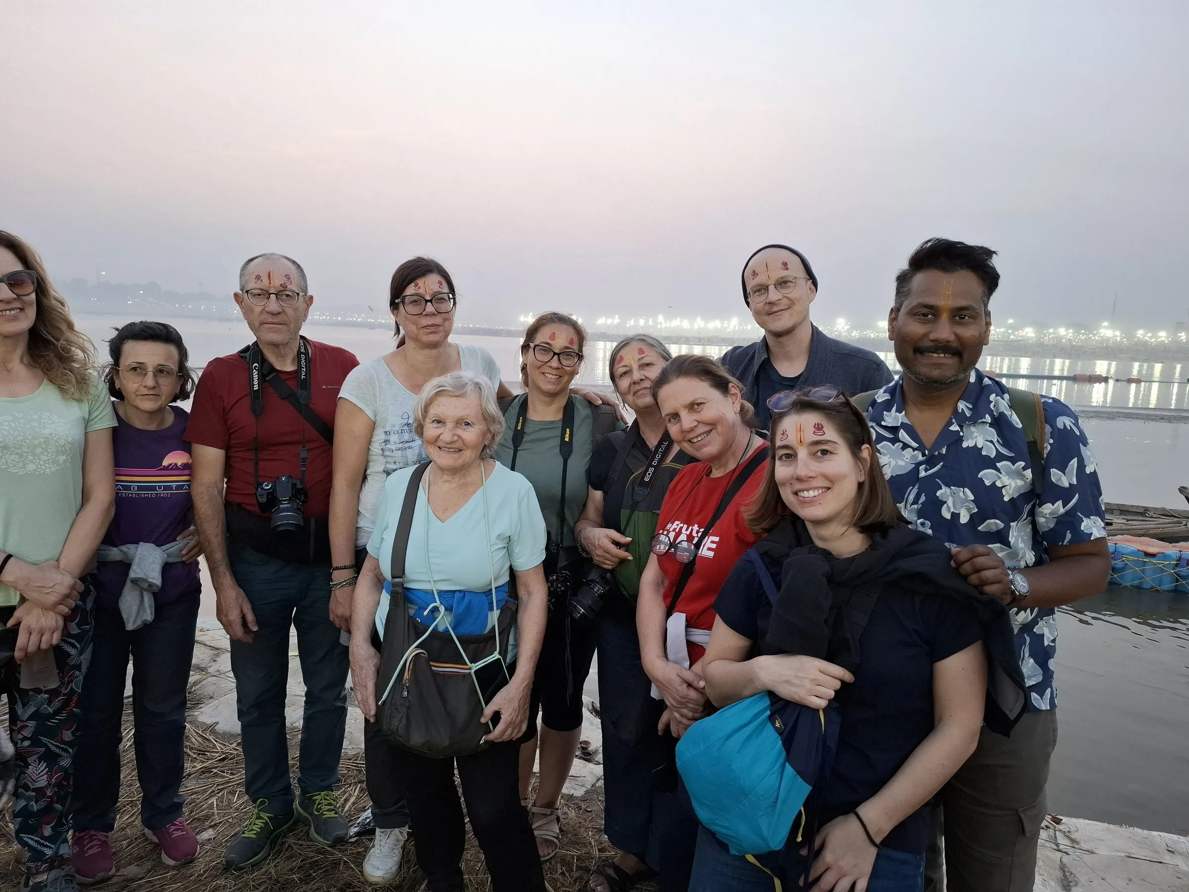 Travellers with the team on the riverbank at dusk
