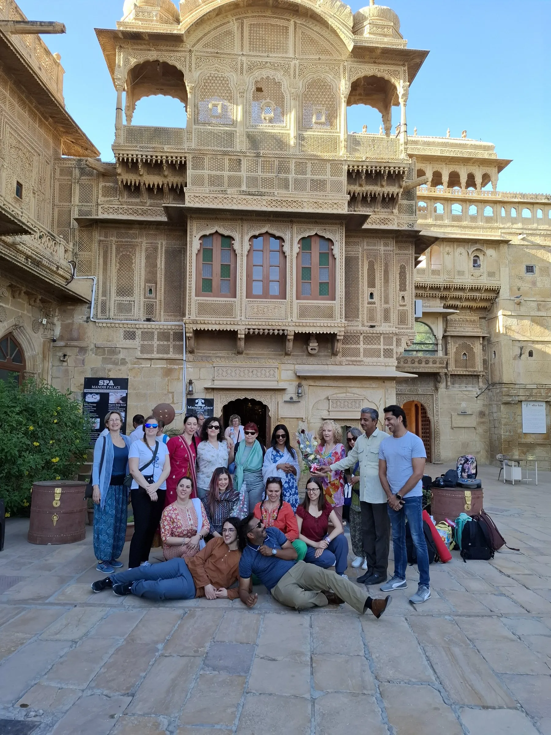 A group in front of a carved sandstone haveli