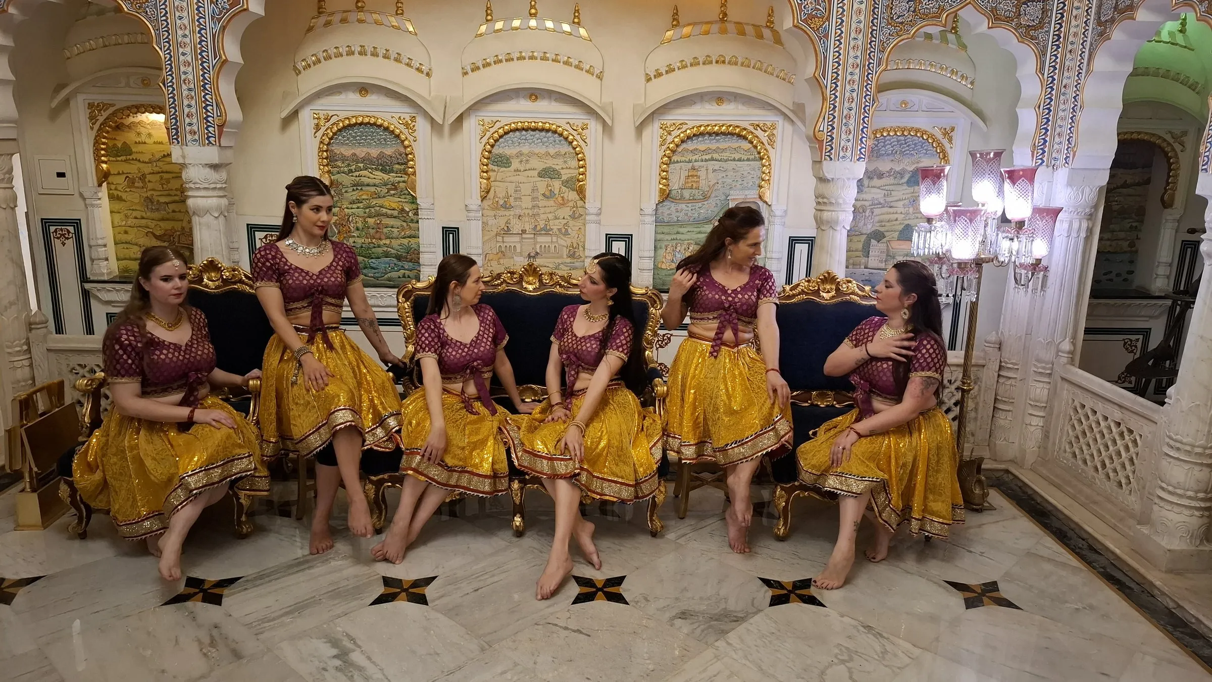 Travellers in Rajasthani dress in a painted hall