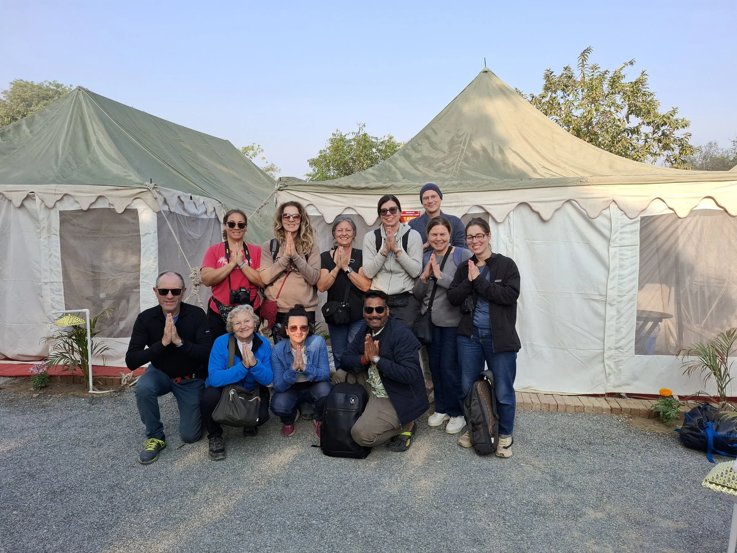 Travellers outside the white tents of the Kumbh camp