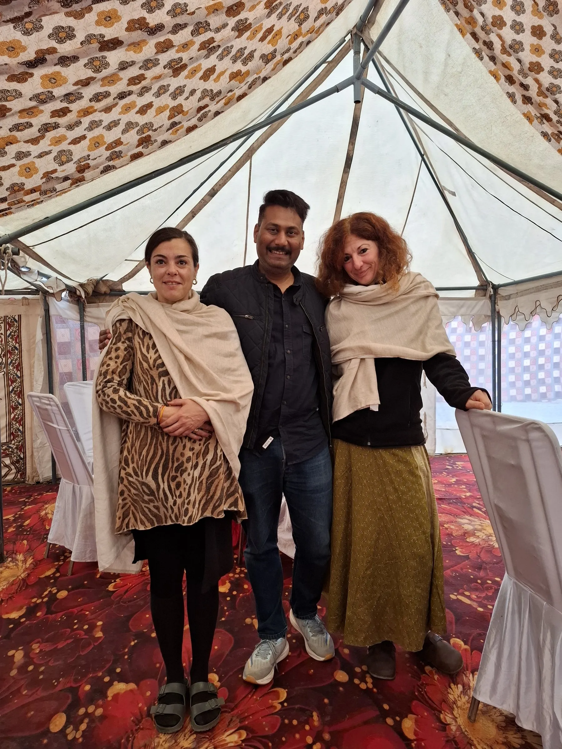 Two travellers with a member of the team inside a camp tent