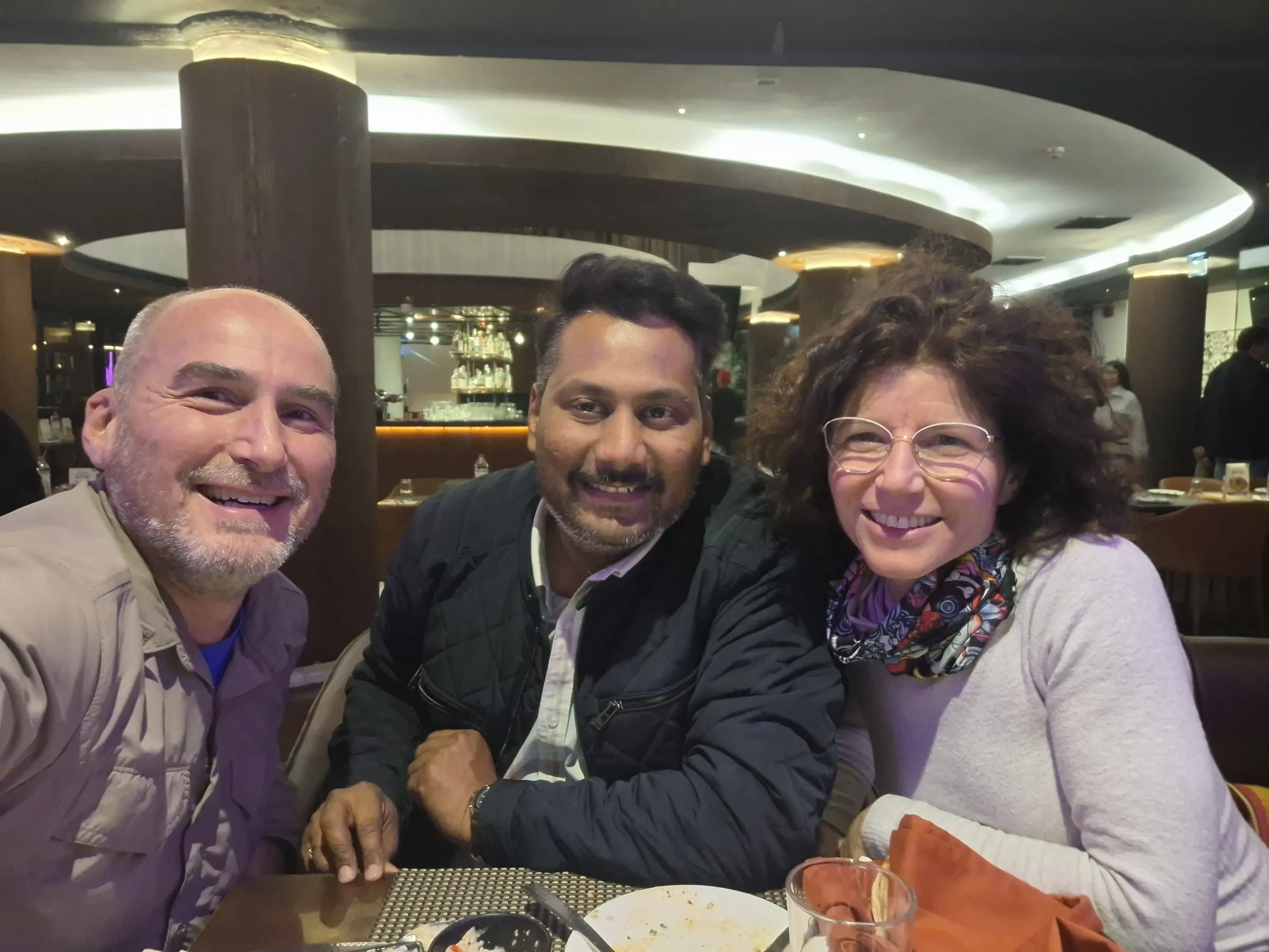 Two travellers with a member of the team at dinner