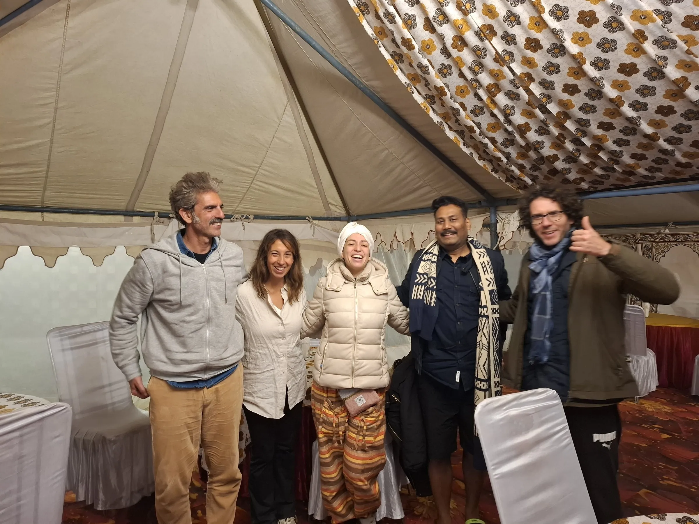 A group of travellers with the team inside a camp tent