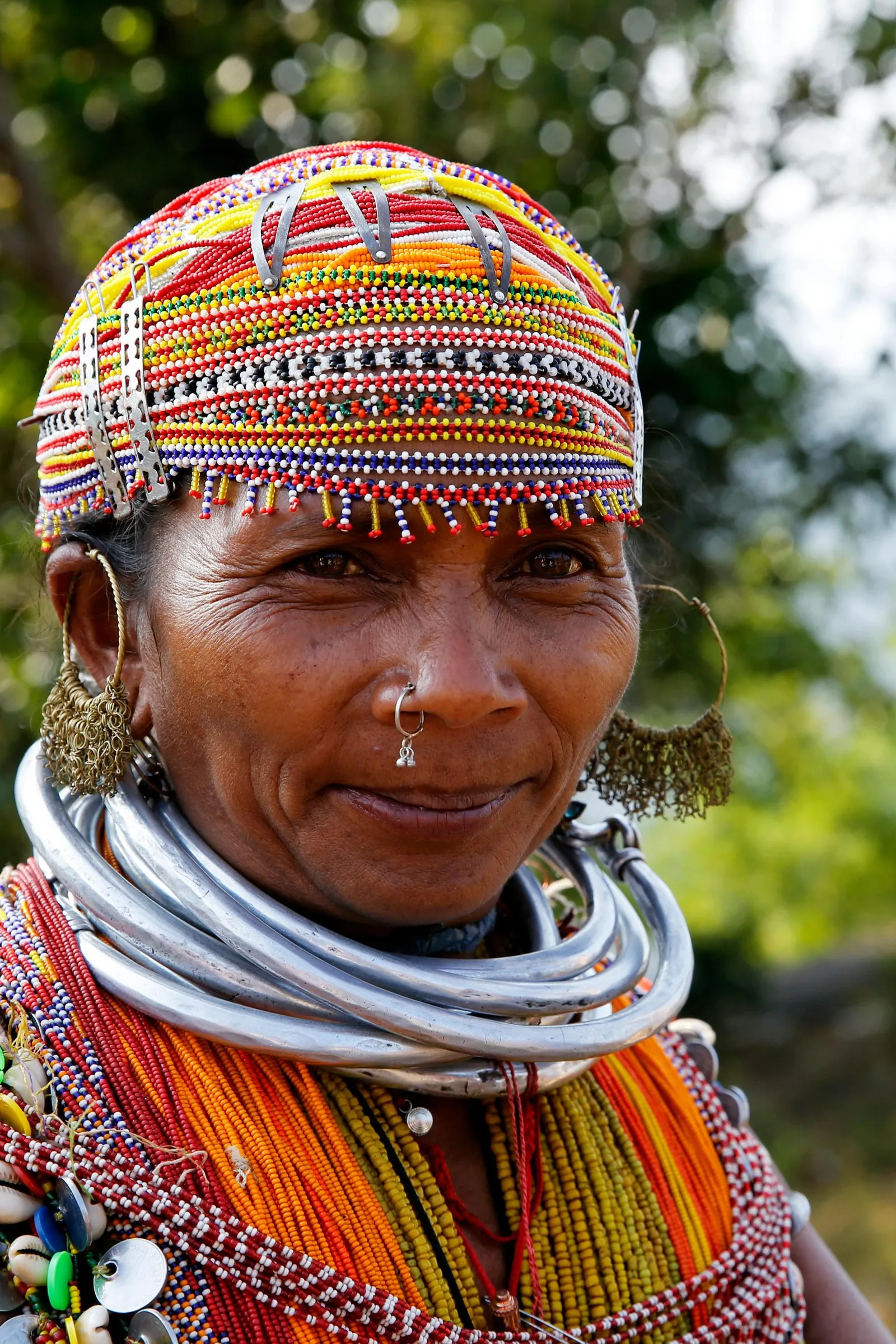 A woman in a beaded cap, bead necklaces and a silver neck ring