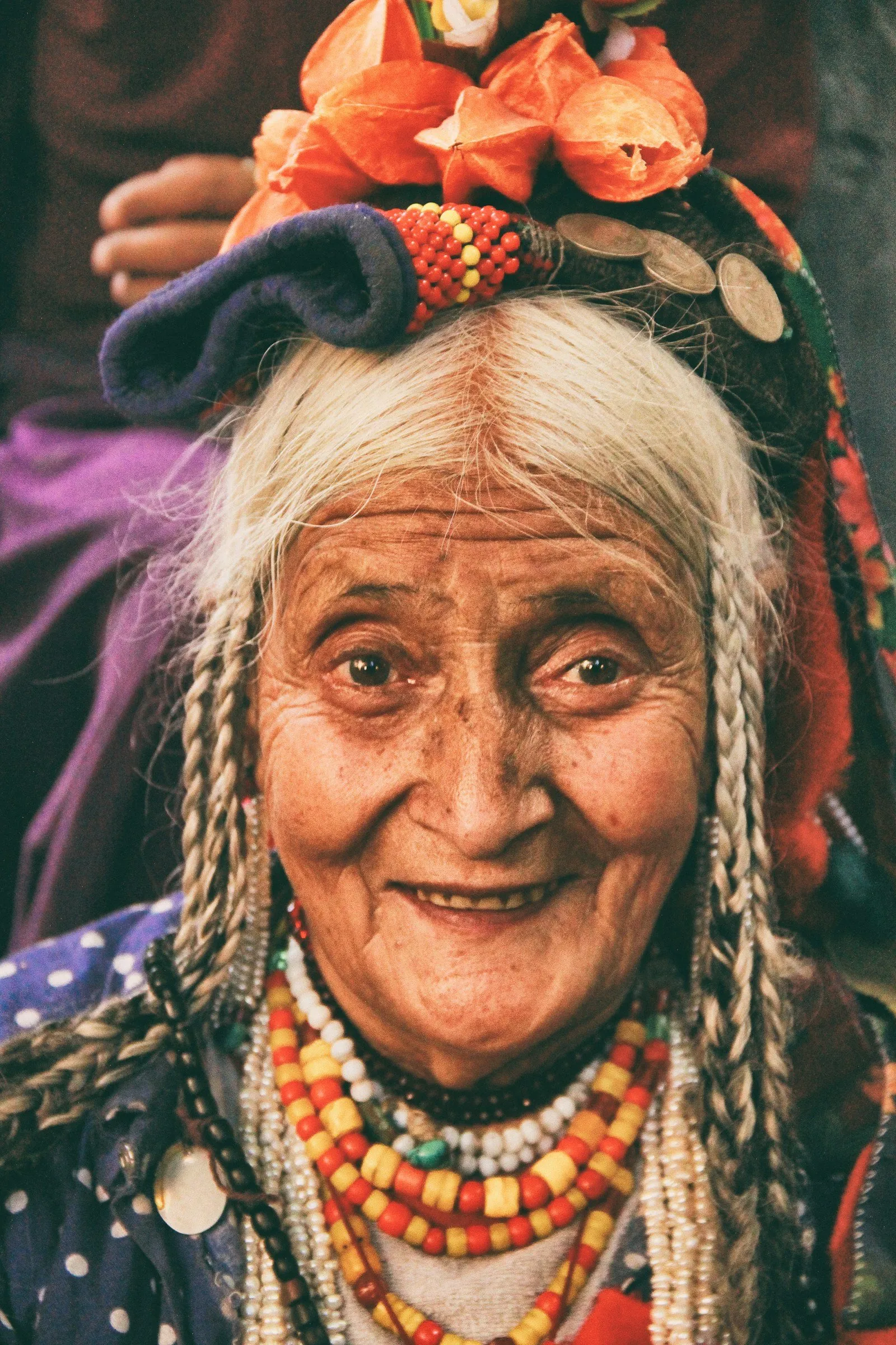 A Brokpa elder in a flower headdress and bead necklaces, Ladakh