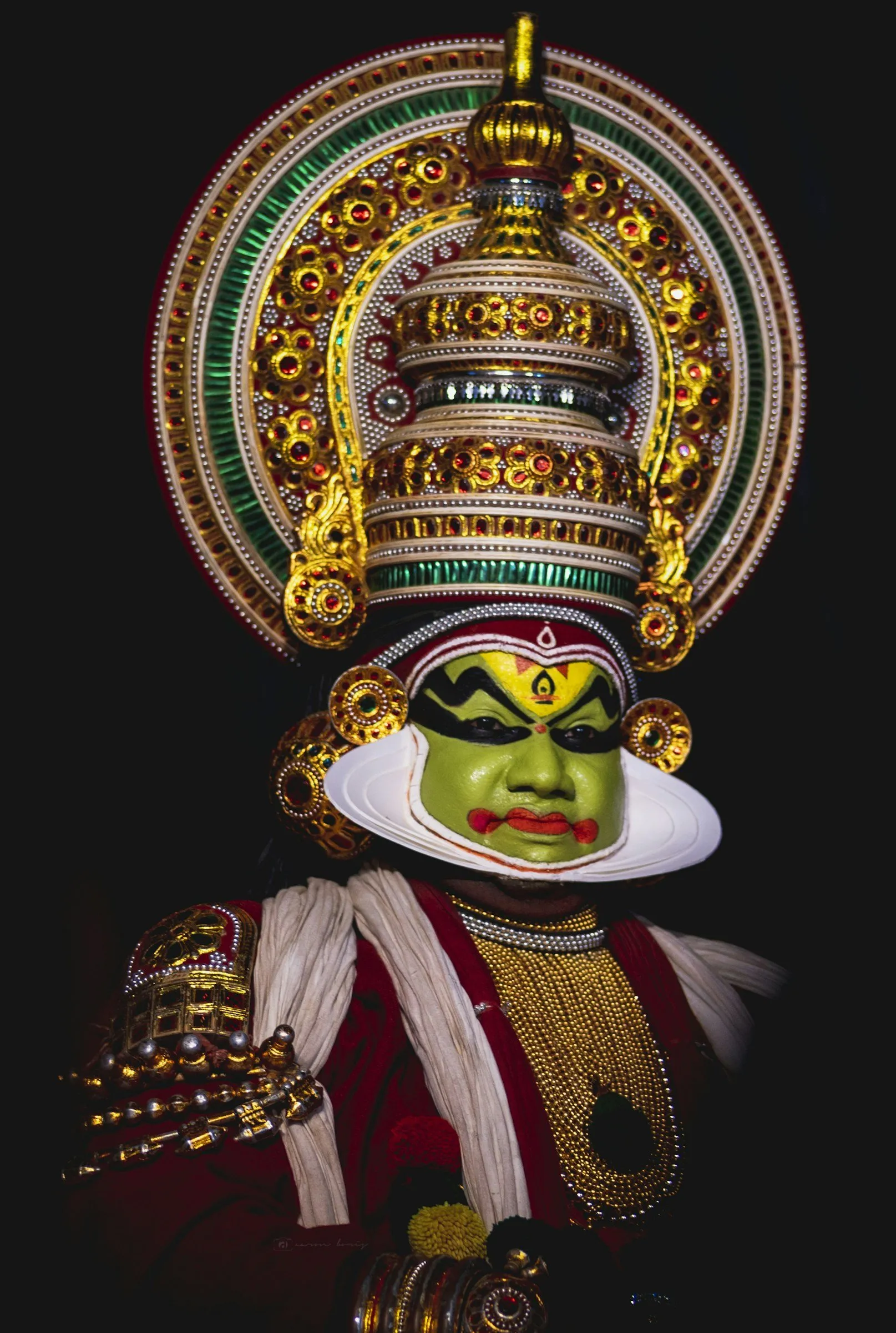 A Kathakali performer in full green make-up and crown