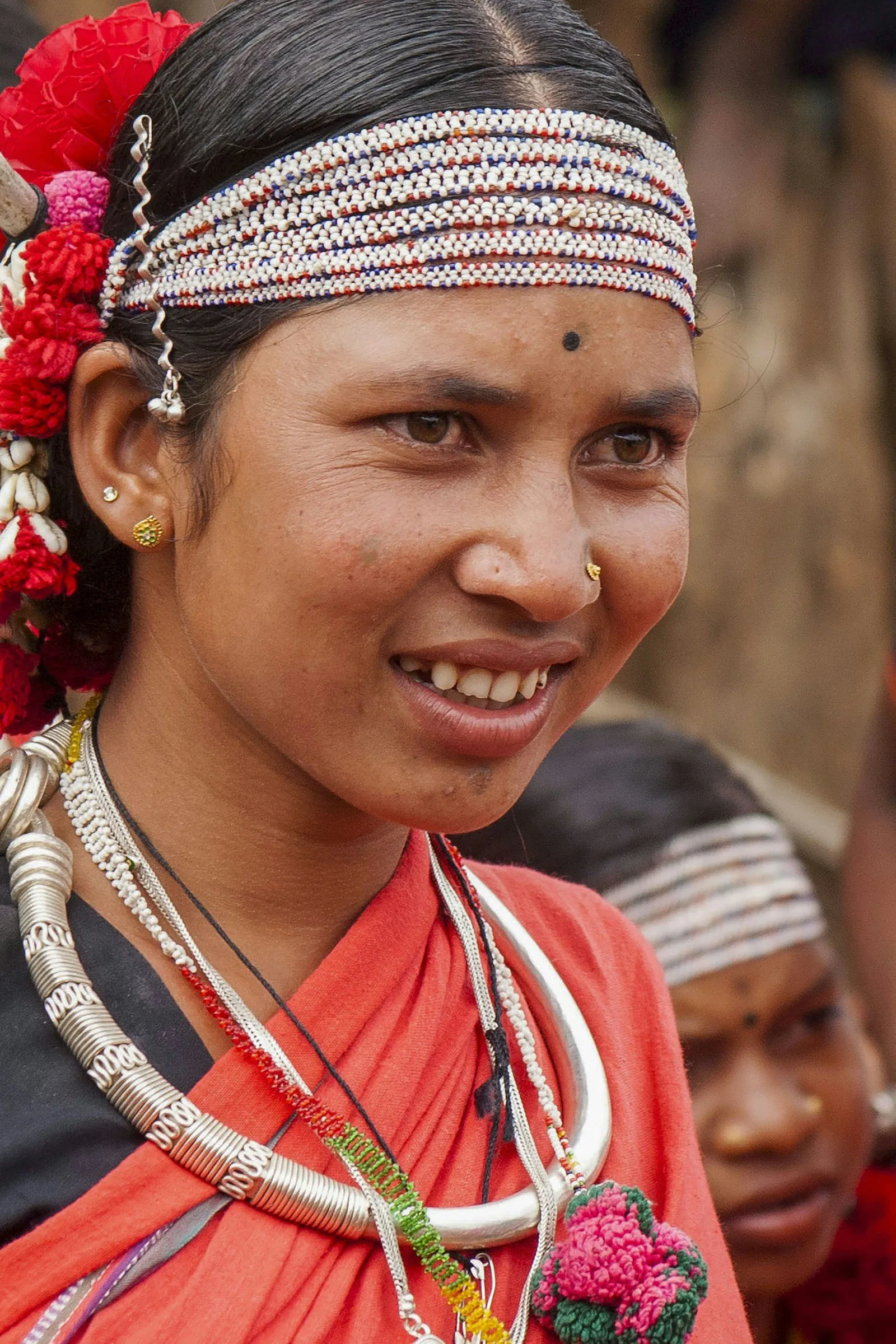 An Adivasi woman with a beaded headband and silver hansuli at a forest-edge village in Chhattisgarh