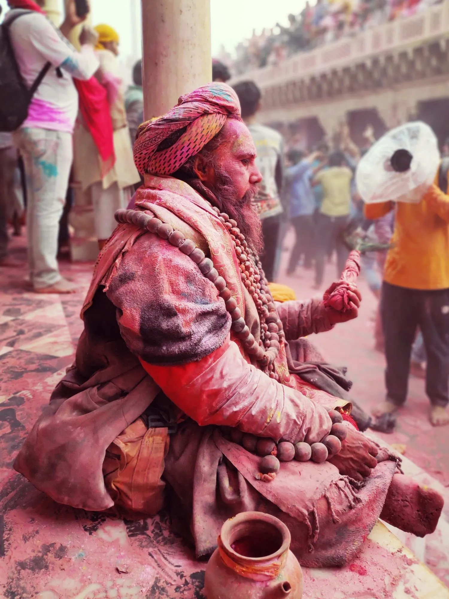 A sadhu covered in colour at Holi