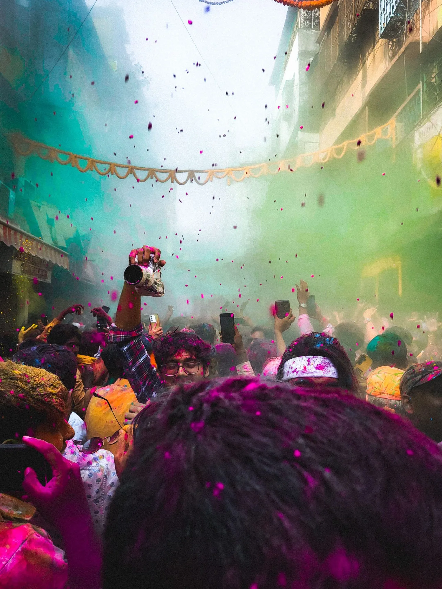 Colour falling through a crowded temple hall at Holi