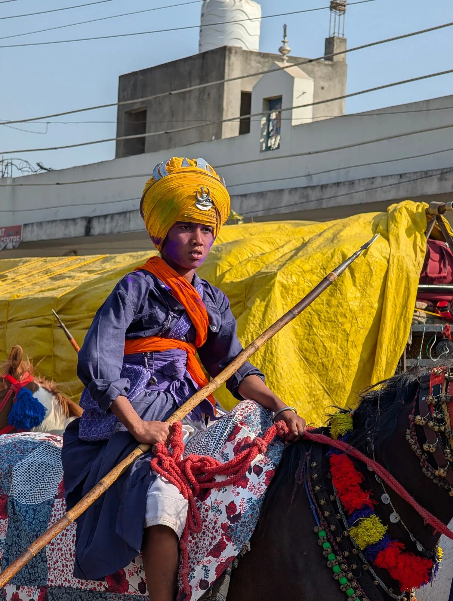 A Nihang Sikh warrior in blue and saffron holding a spear