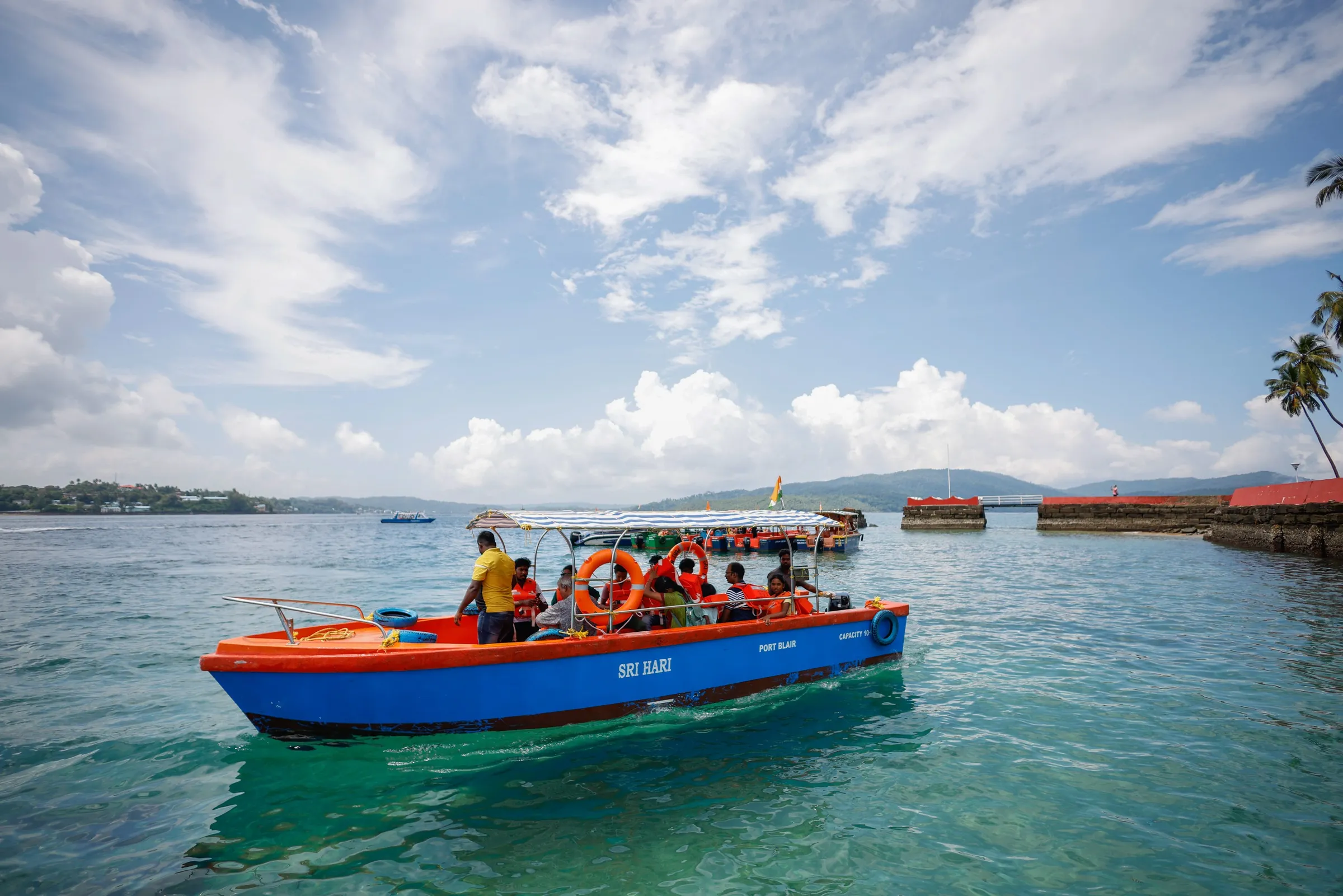 A painted wooden boat on clear water at Port Blair