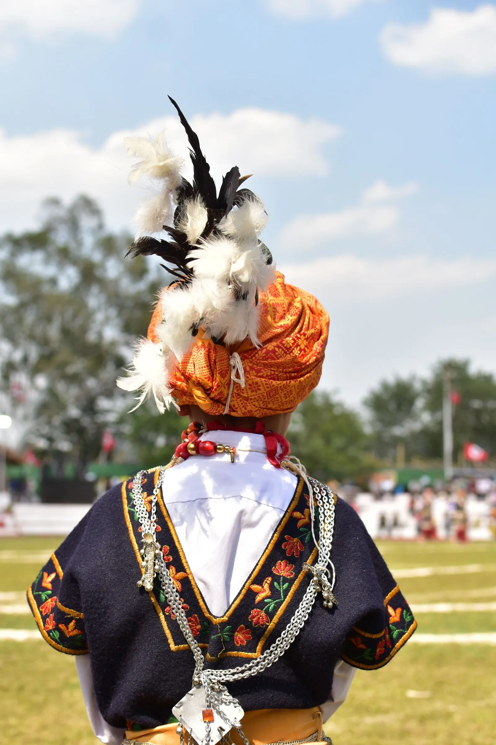 A Khasi dancer in a plumed orange turban and silver ornaments at a festival in Shillong