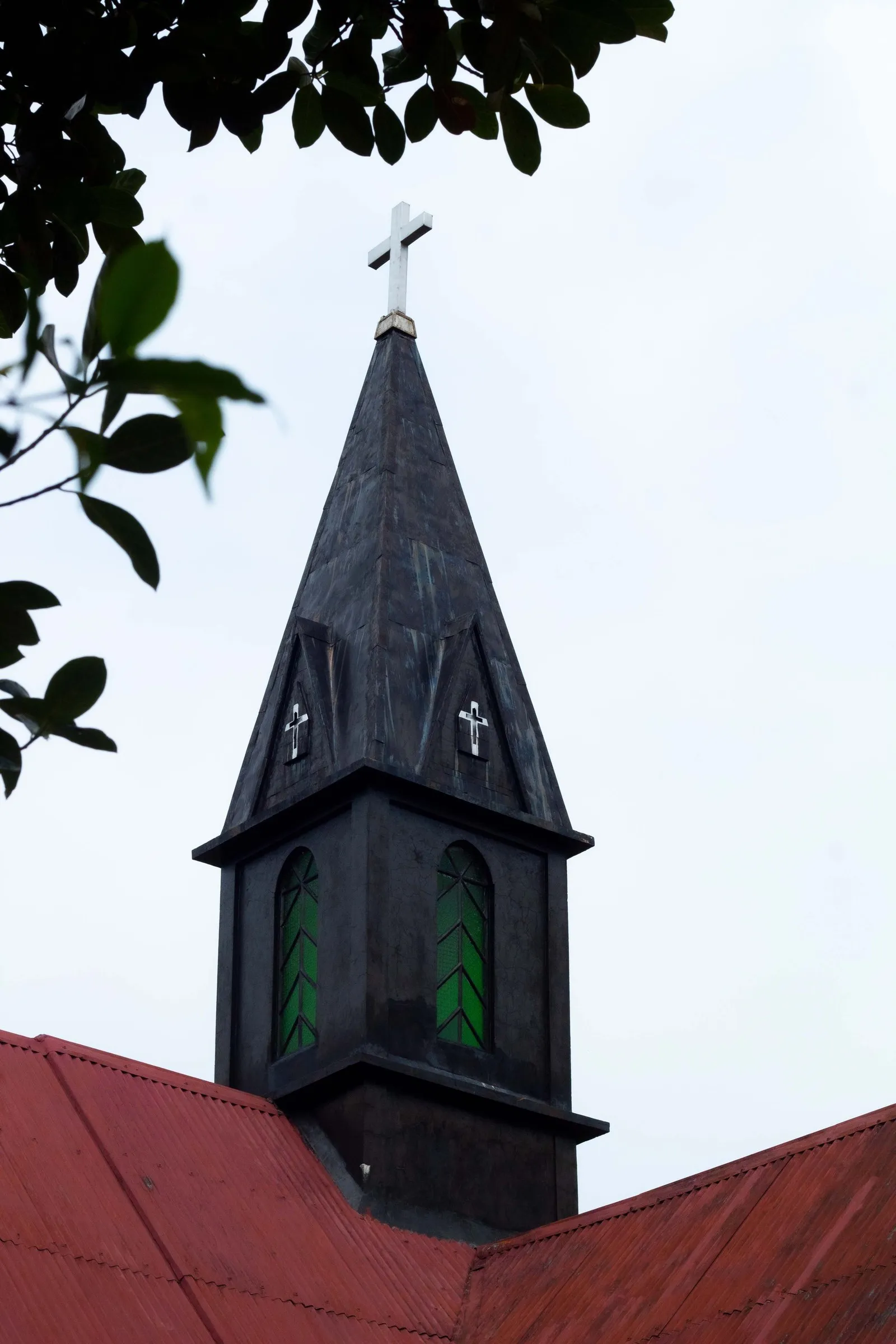 The steeple of the church at Mawlynnong, above its red tin roof