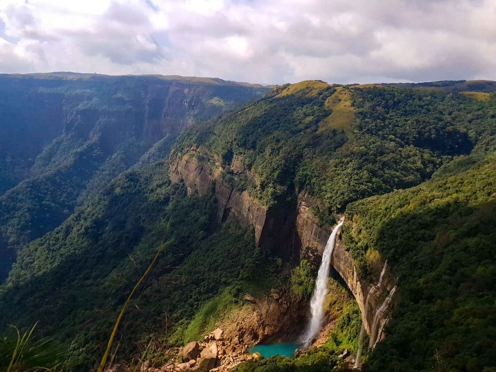 Nohkalikai Falls dropping from the plateau edge into its green pool, near Cherrapunji