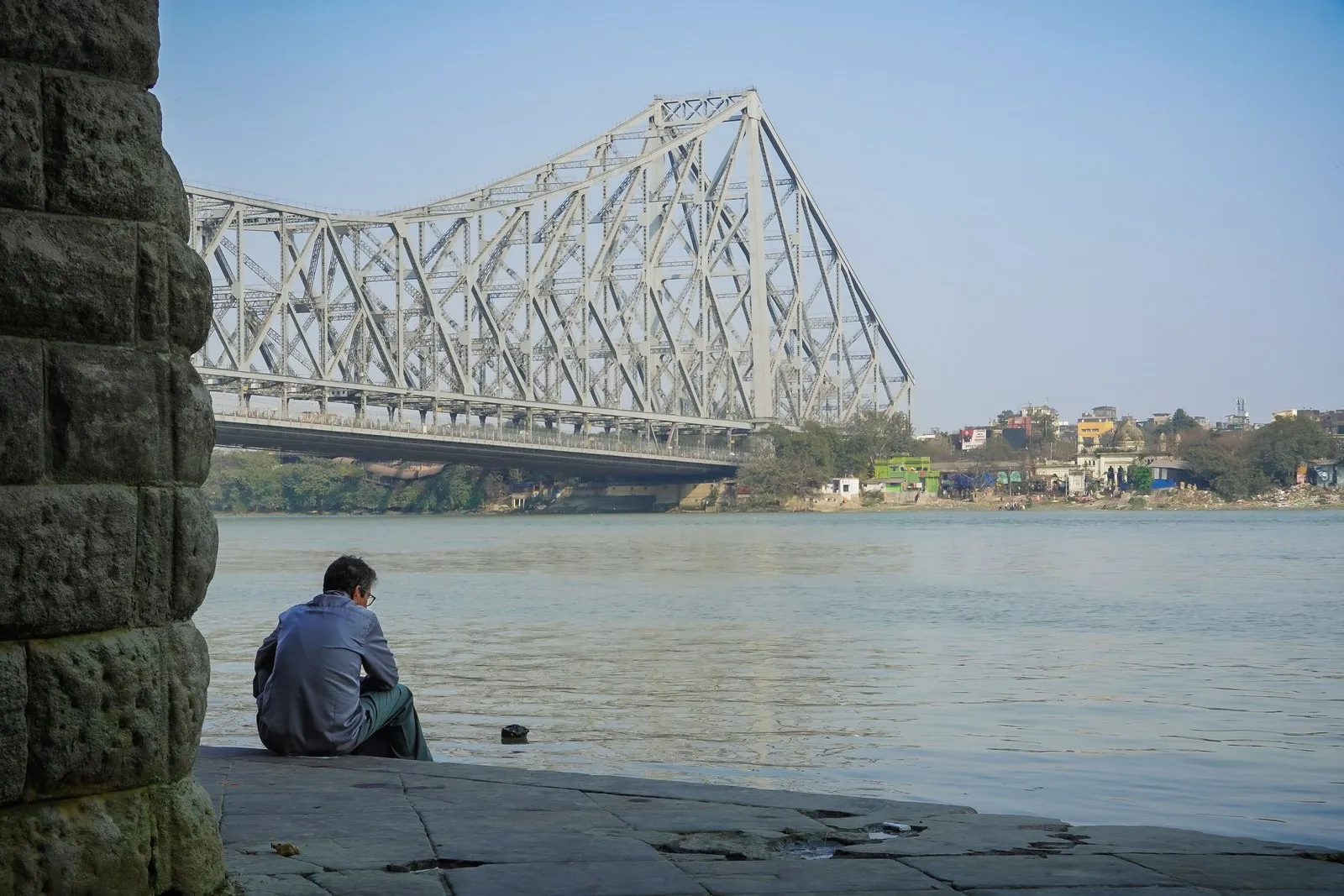 A man sitting on the ghat by the Hooghly below Howrah Bridge, Kolkata