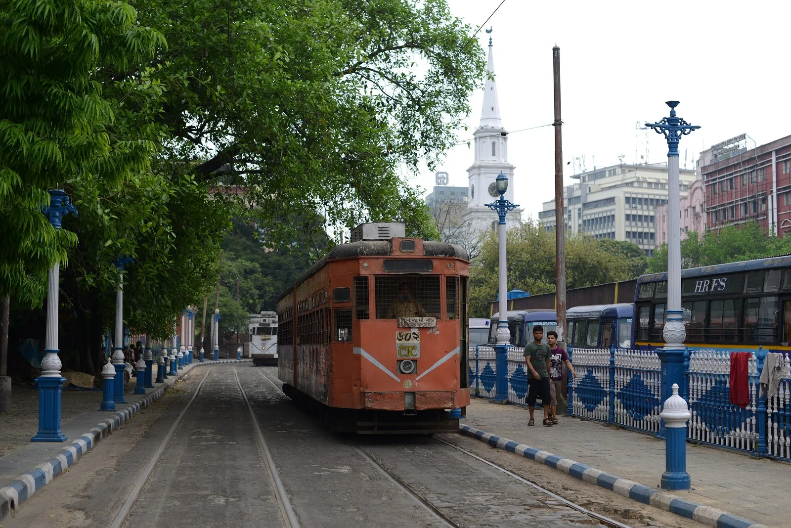 An old tram on a tree-lined street at BBD Bagh, Kolkata