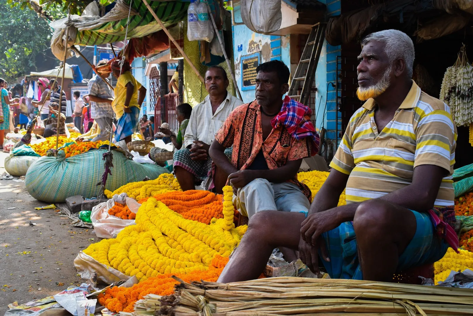 Flower sellers waiting among heaps of marigolds at a Kolkata market