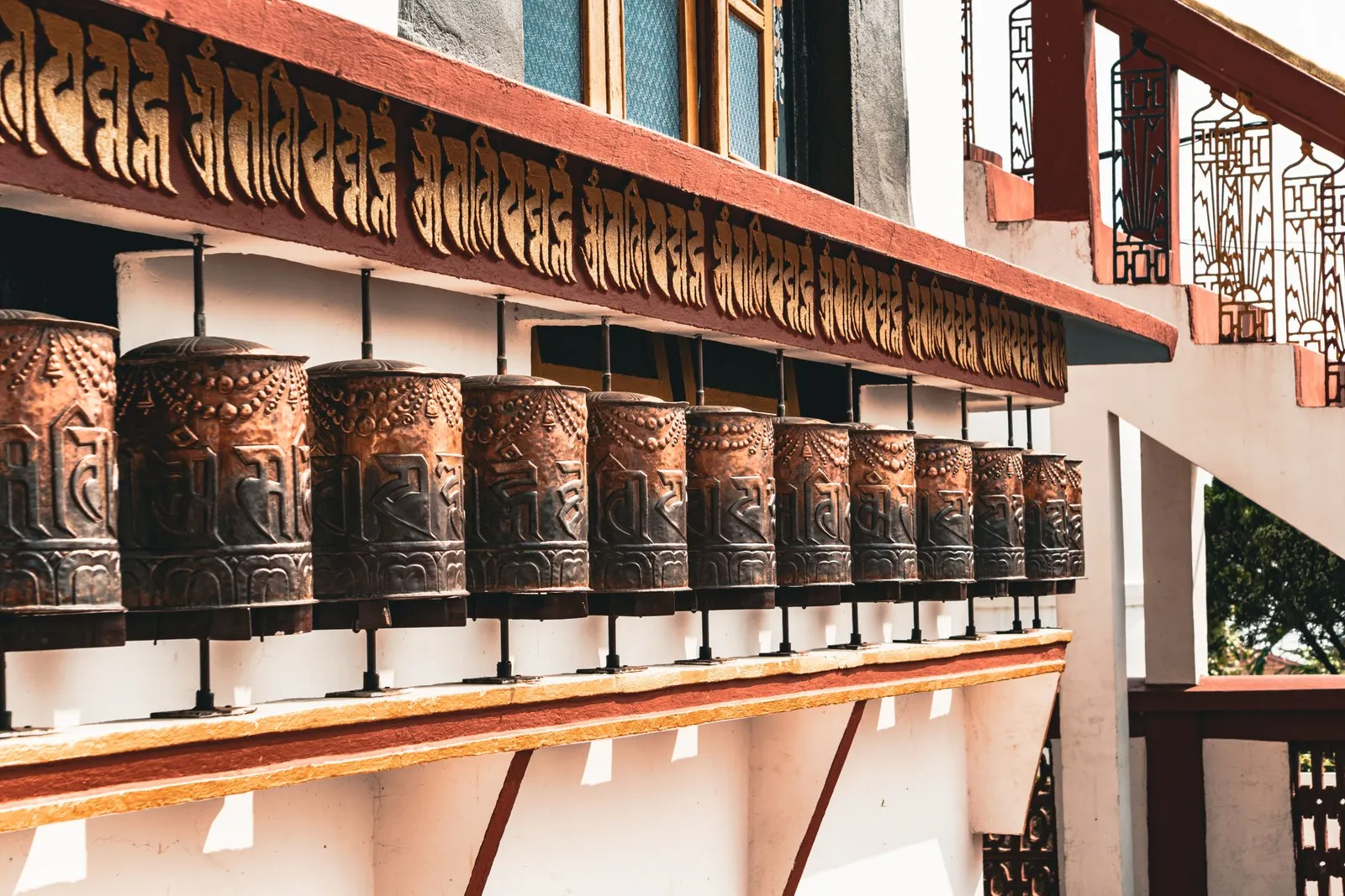 Carved prayer wheels along a monastery wall in Kalimpong