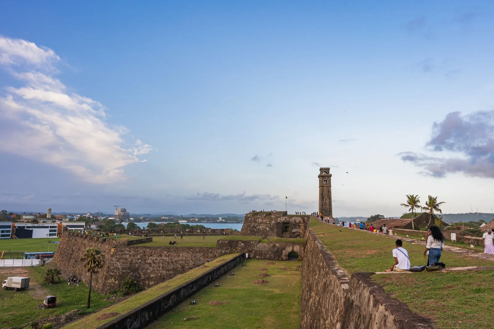 People on the ramparts of Galle Fort in the evening, the clock tower beyond