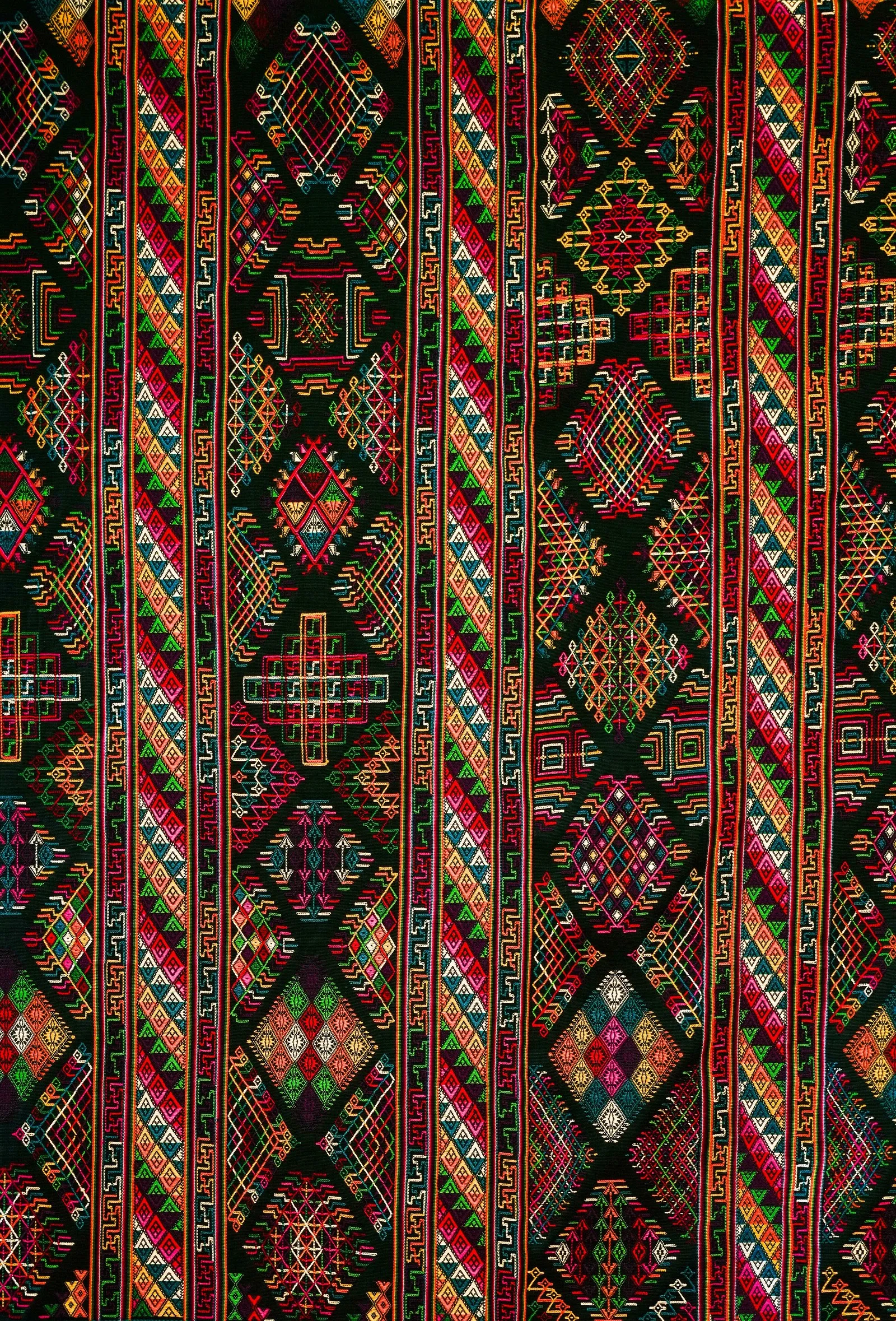 A handwoven Bhutanese textile, patterned in reds, greens and gold