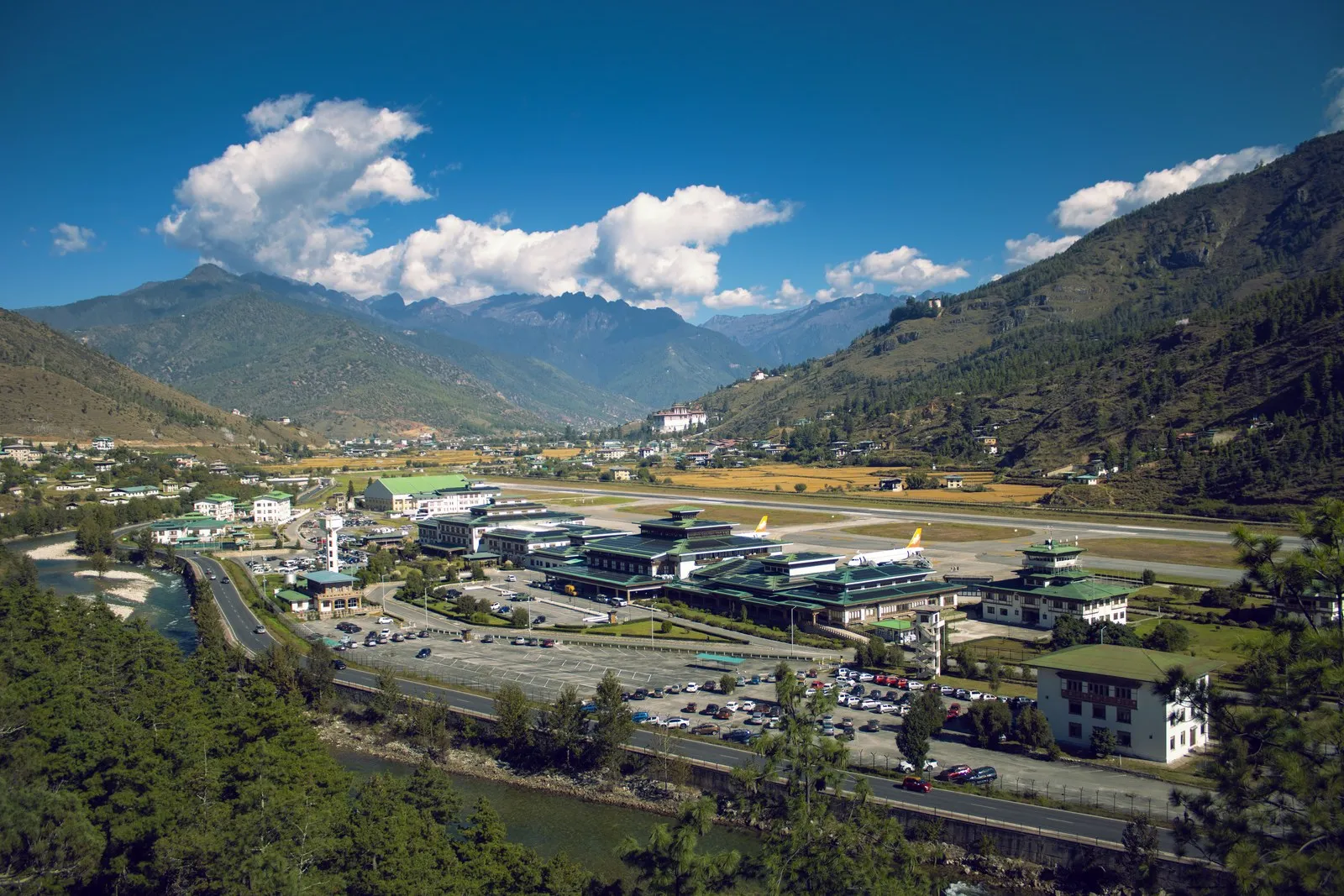 Paro airport in its valley from the hillside above, the town and the river beside it