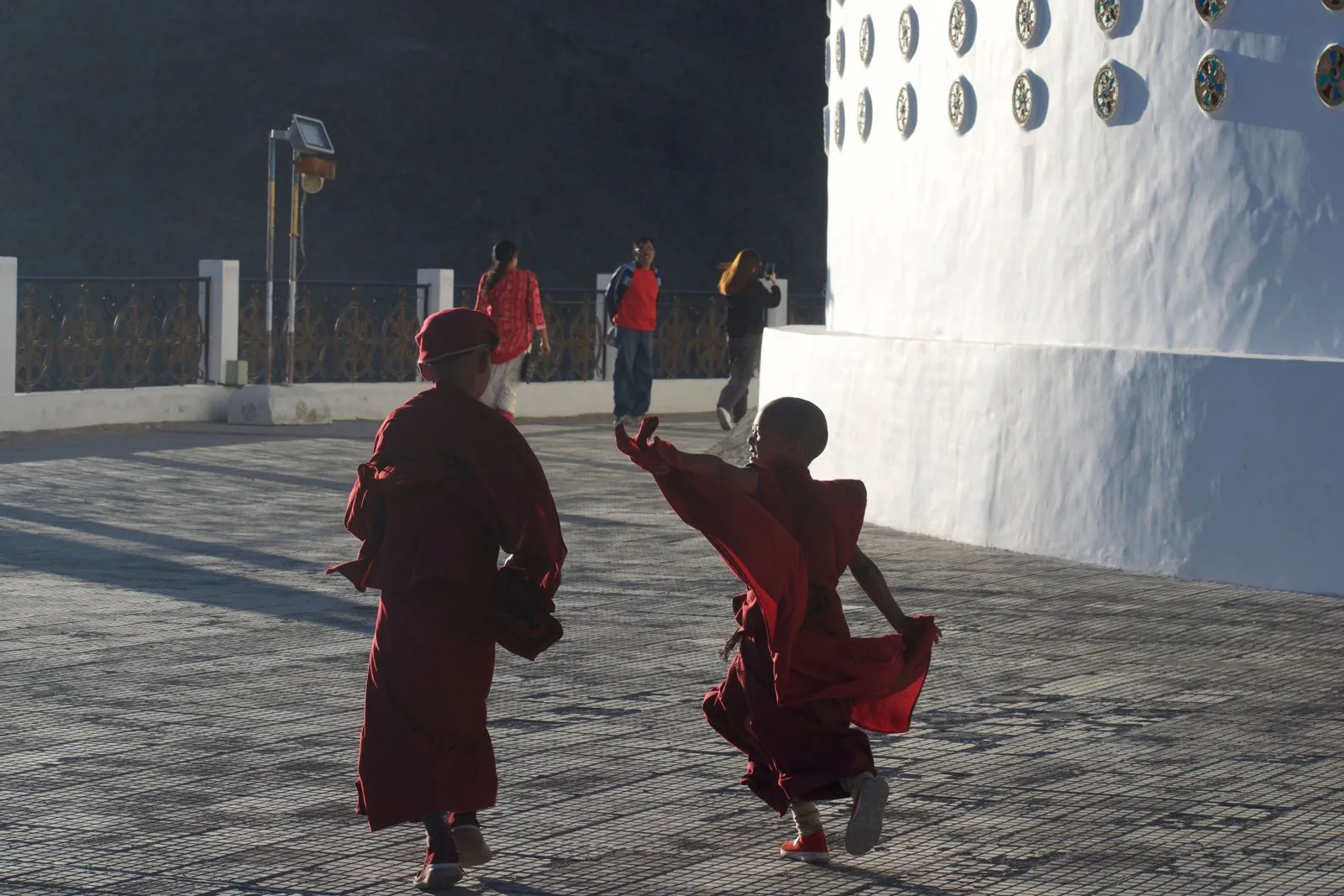 Two novice monks playing in a temple courtyard, Bhutan