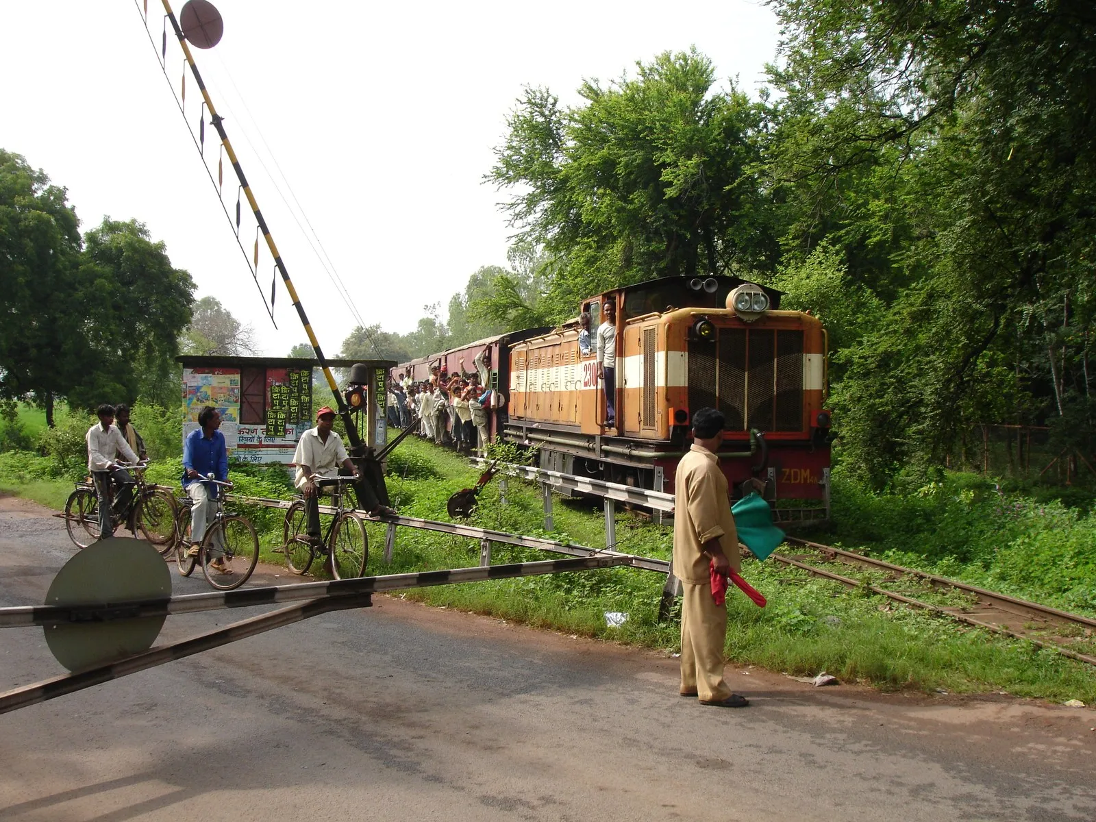 A narrow-gauge train crossing a village road on its way to Raipur