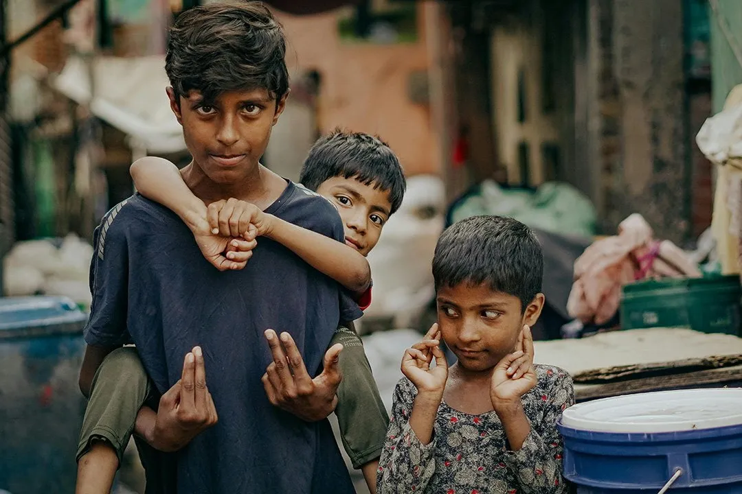 Three boys in a Delhi market lane
