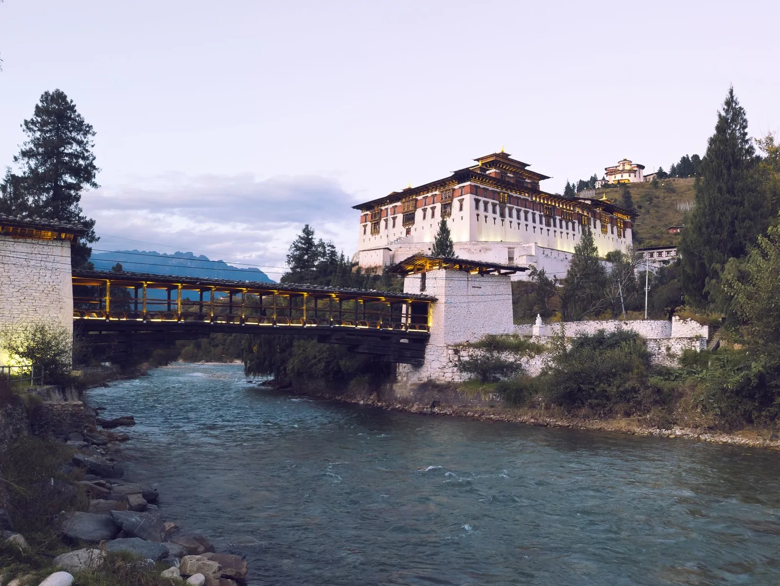 Rinpung Dzong above the Paro river, with the covered bridge in front, at dusk