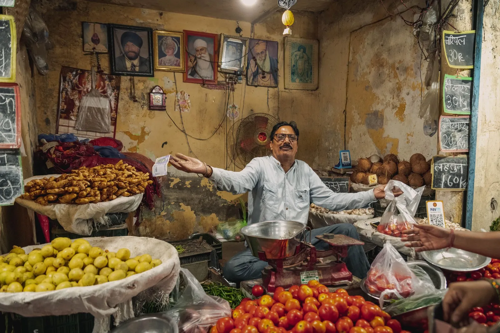 A vendor at his stall of fruit and vegetables in a Delhi market
