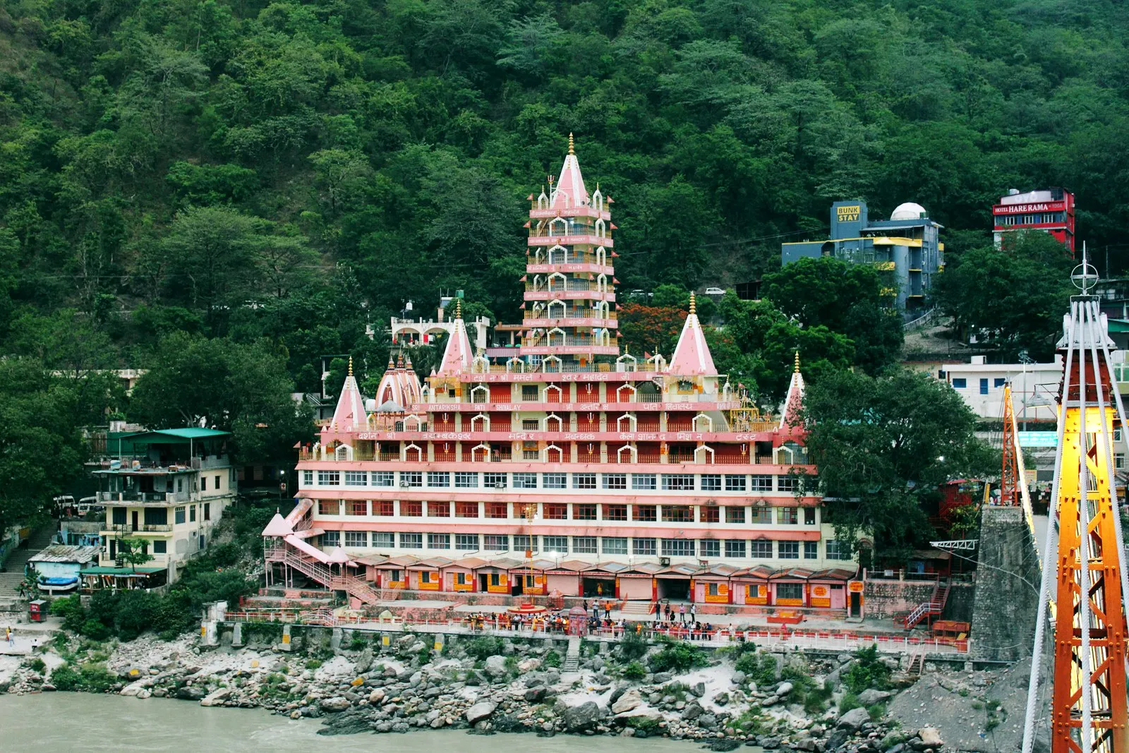 The Tera Manzil temple beside a tower of the Laxman Jhula, above the Ganga at Rishikesh