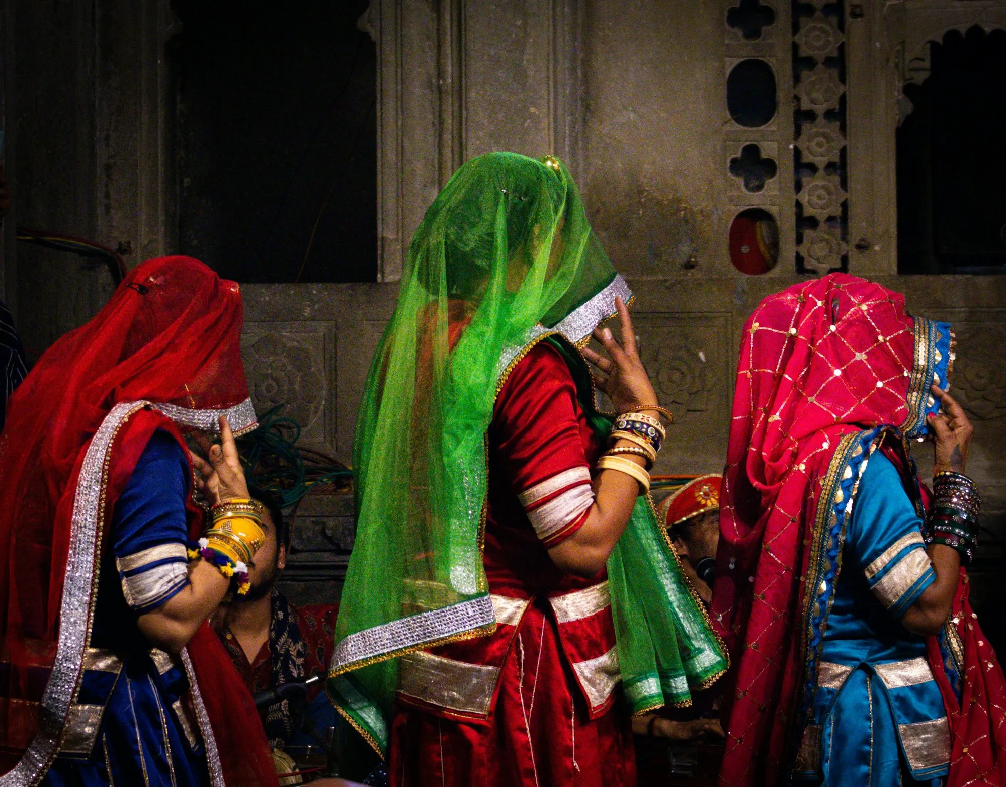 Three women in bright veils and bangles in a Jaipur palace