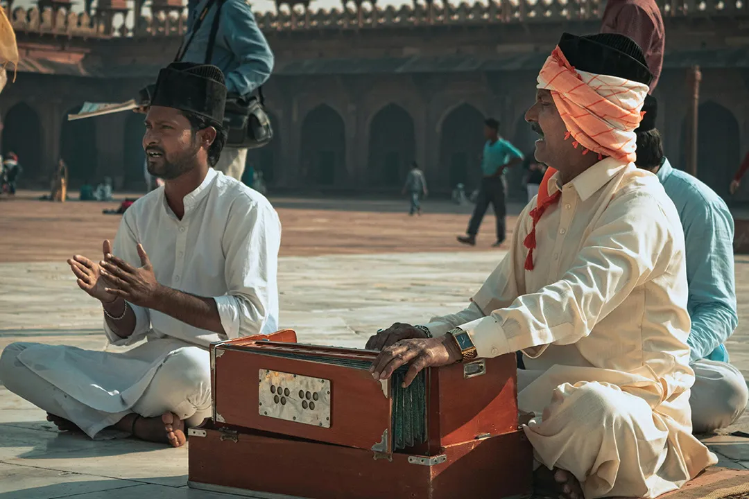Singers with a harmonium in a courtyard