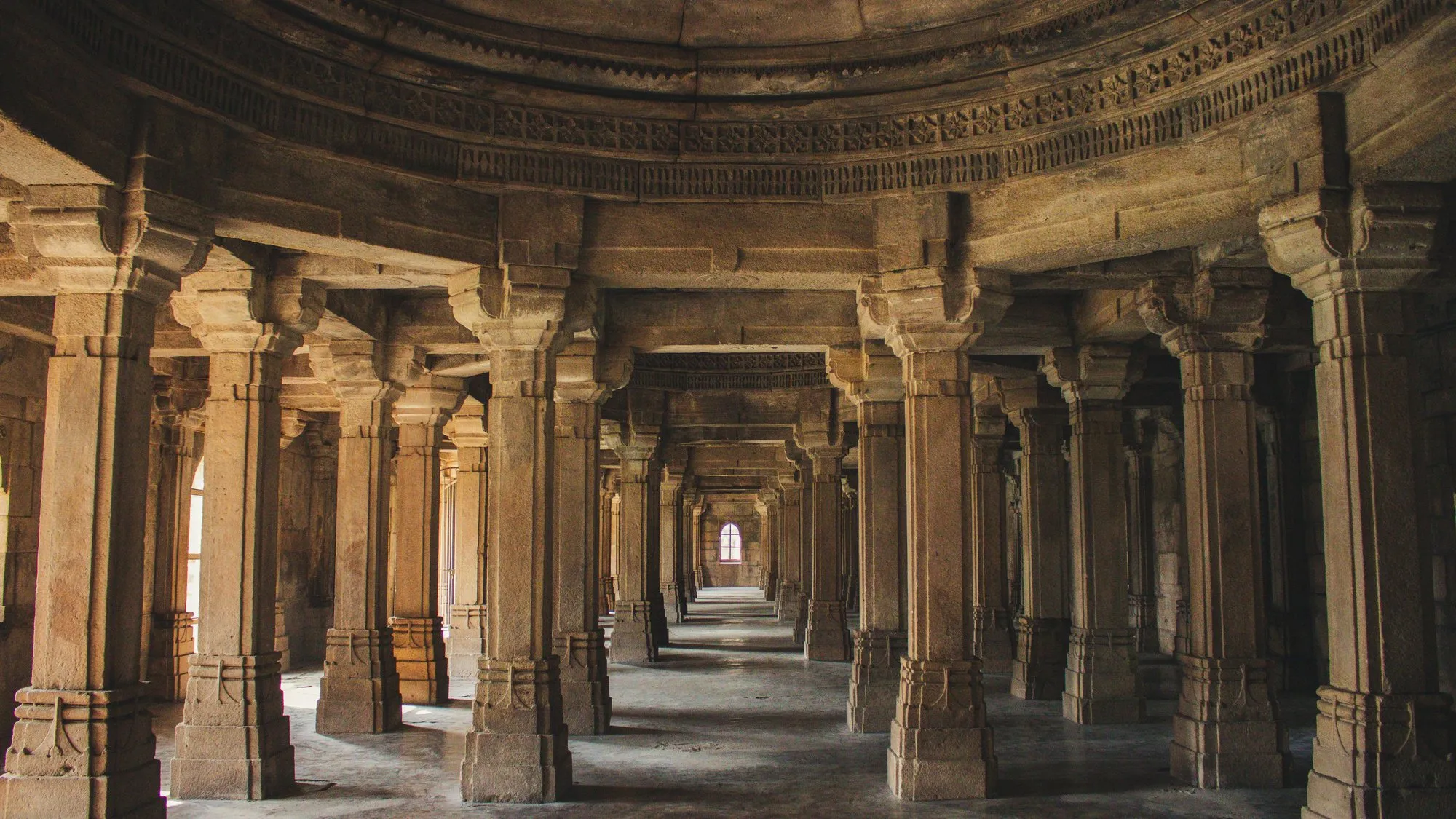 Rows of carved pillars in a mosque hall
