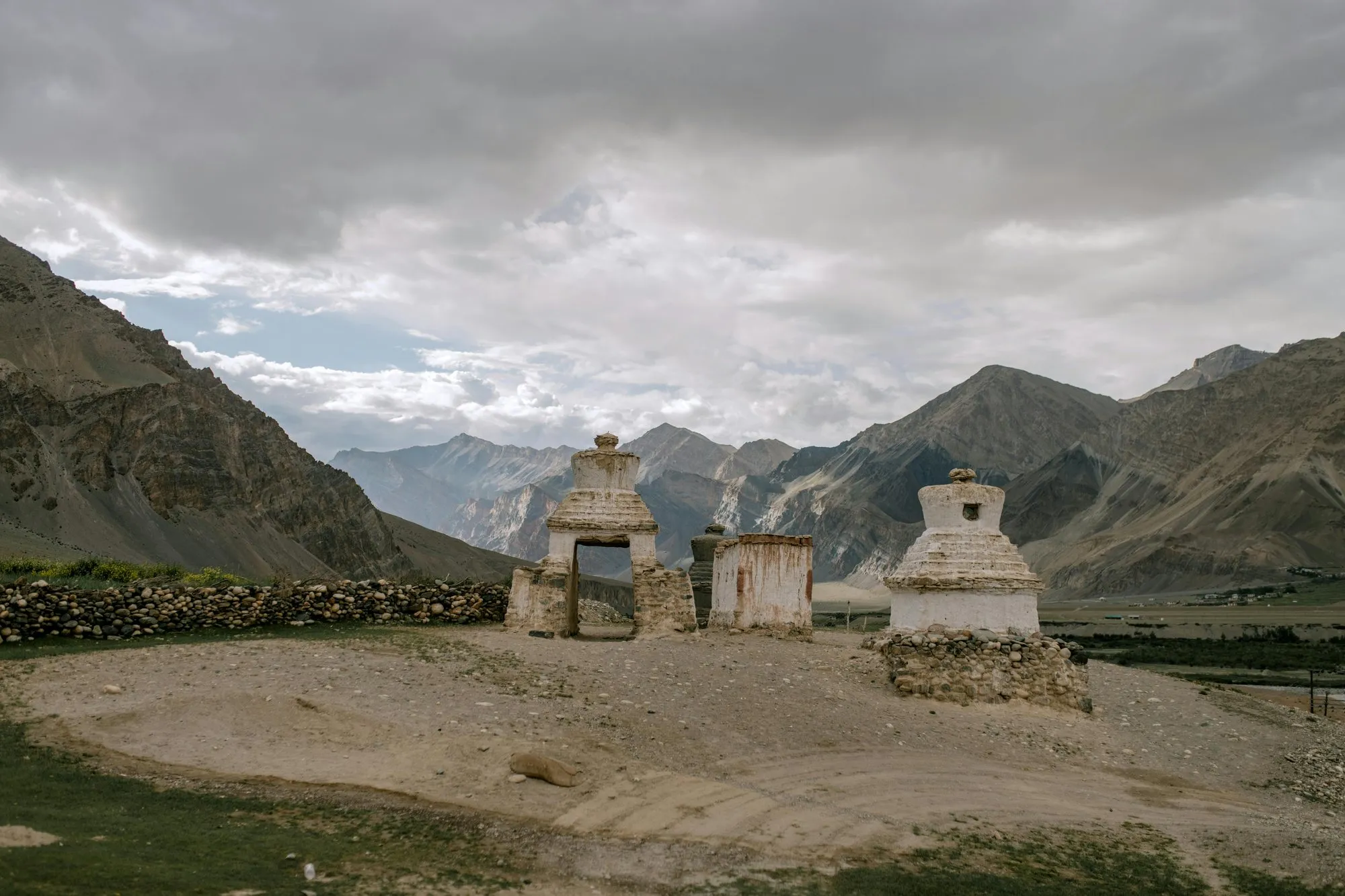 Whitewashed stupas in a wide mountain valley