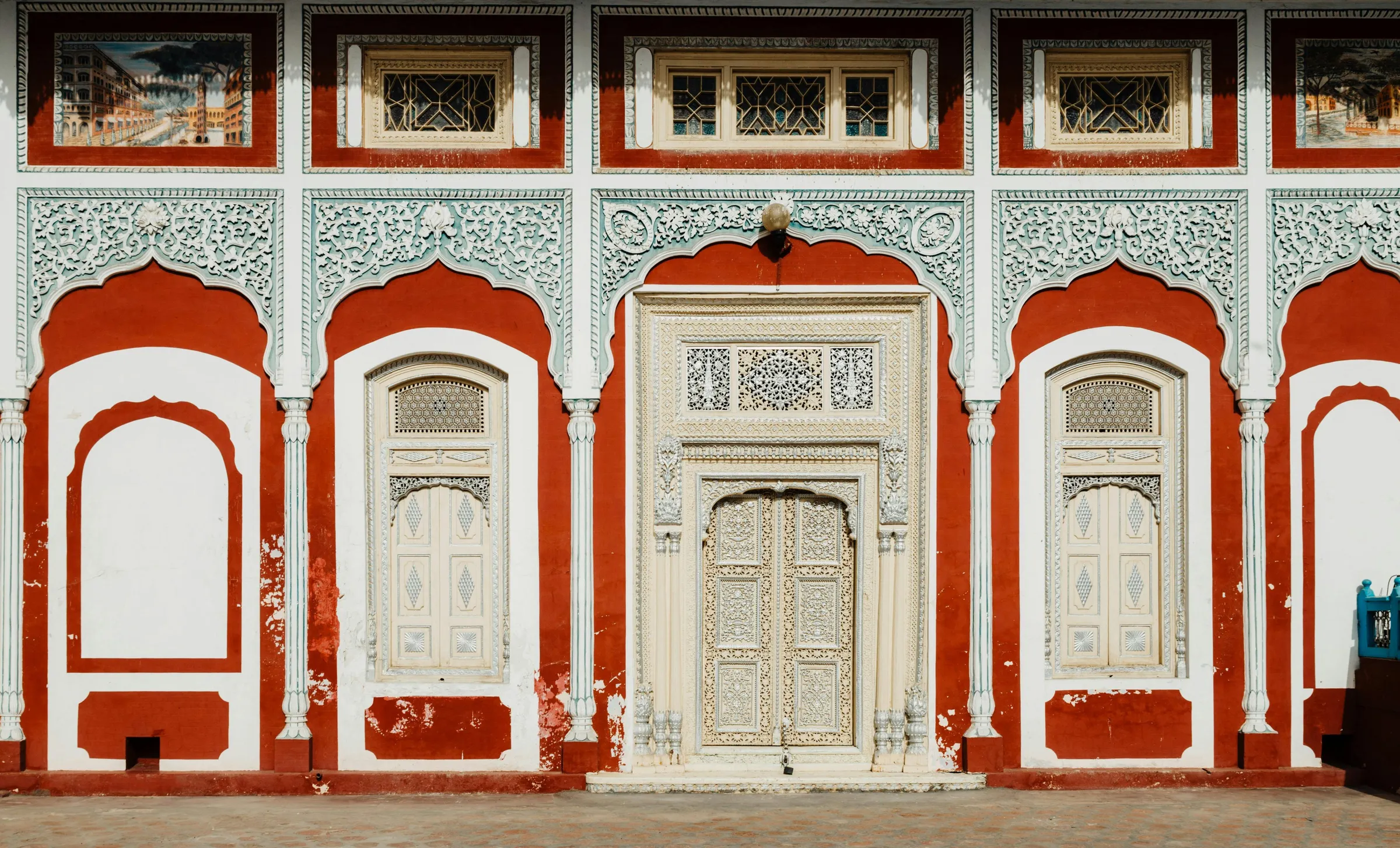 A haveli front painted in red and white with carved doors
