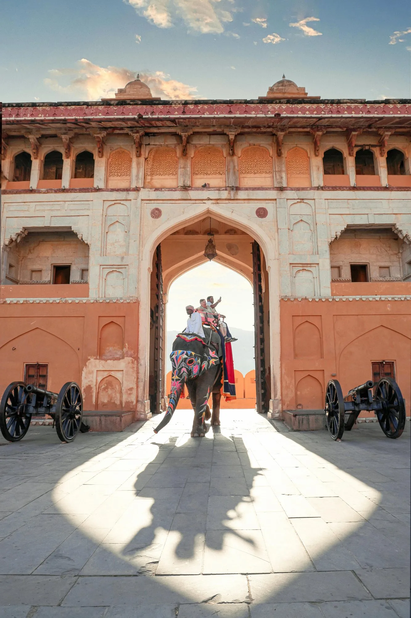 An elephant passing through a pink palace gateway