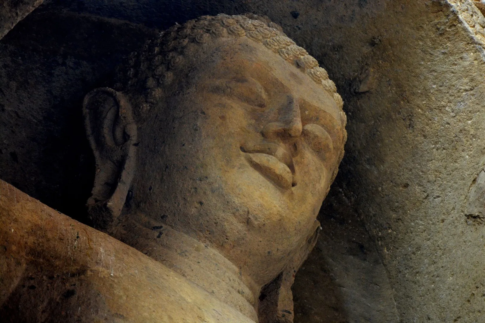 The face of the reclining Buddha carved in the rock at Ajanta