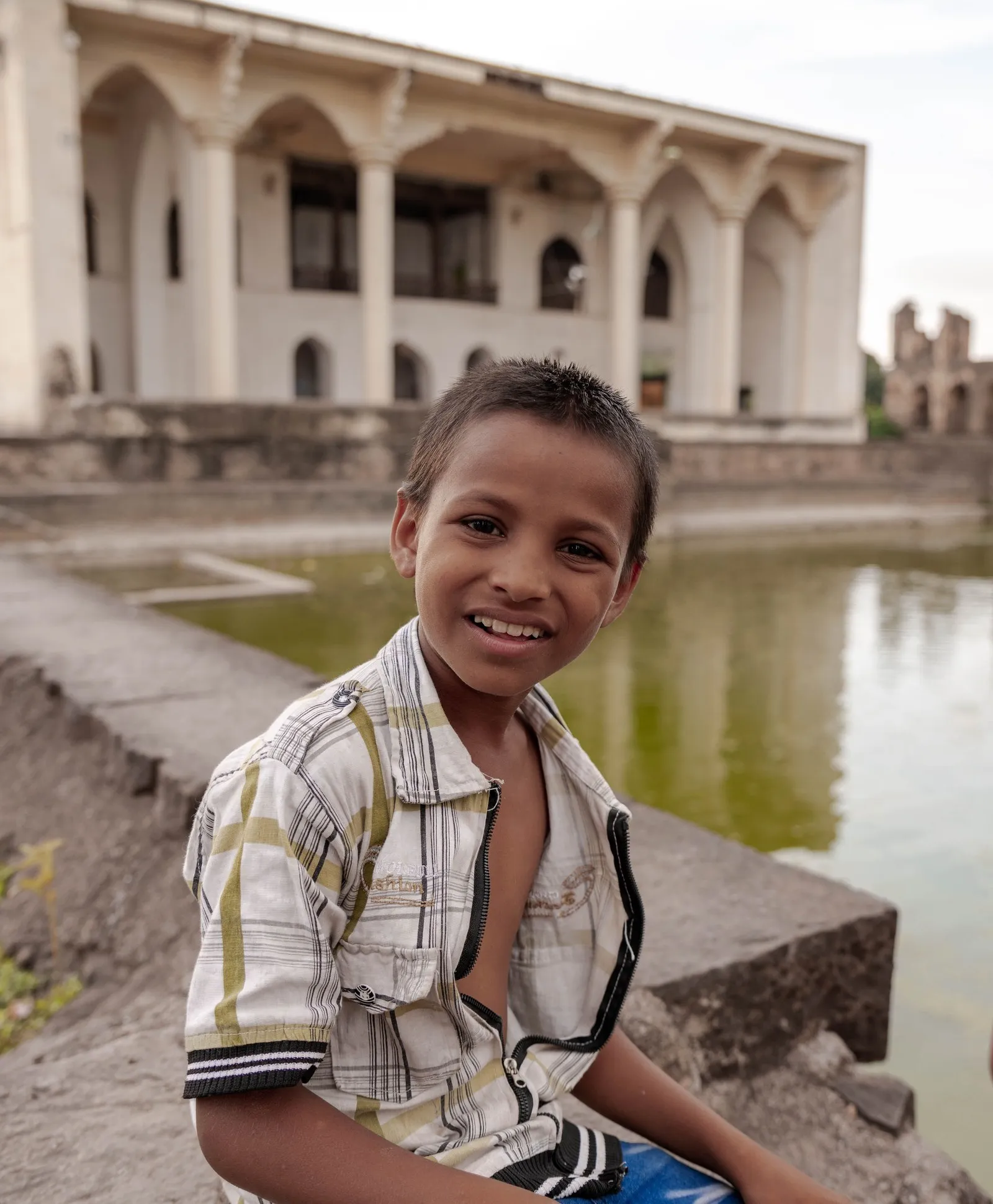 A boy beside an old water tank in Bijapur