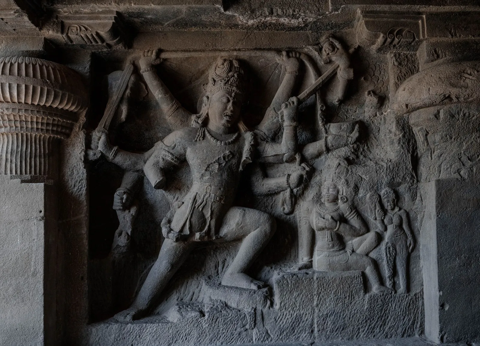 A many-armed figure carved in relief in a Hindu cave at Ellora