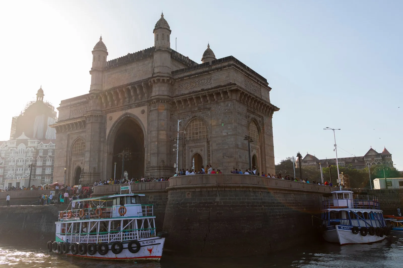 Ferries moored below the Gateway of India, Mumbai, with visitors on the waterfront