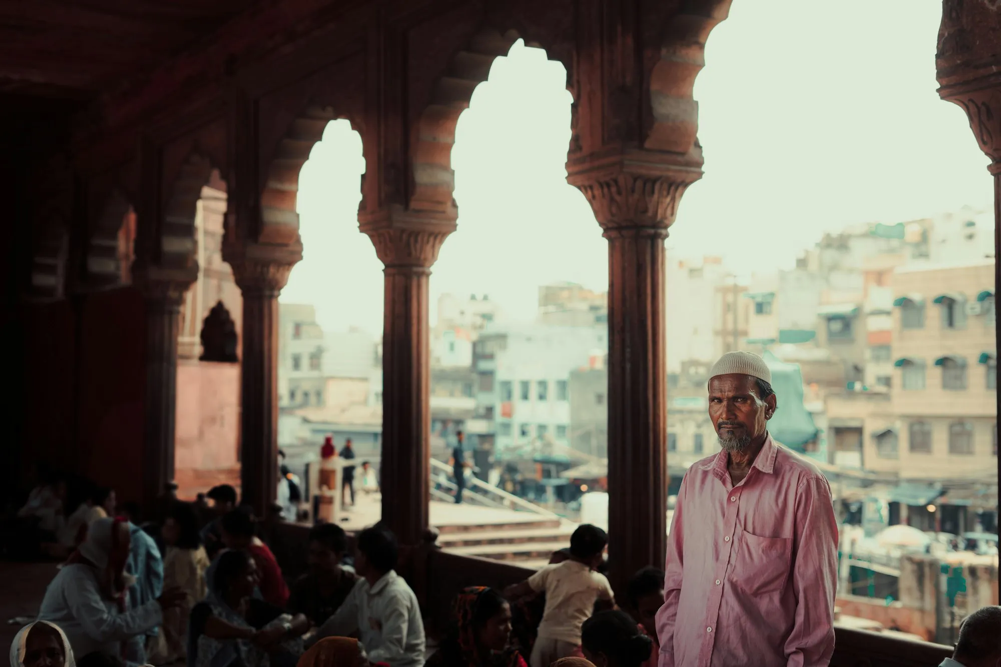 A man in a pink shirt beneath the arches of the Jama Masjid