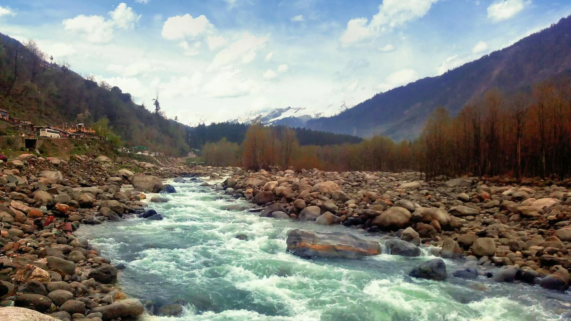 A river running over boulders through a pine valley