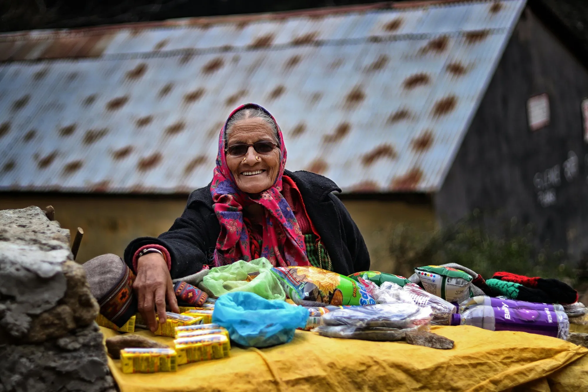 A woman in a headscarf selling woollens at a stall