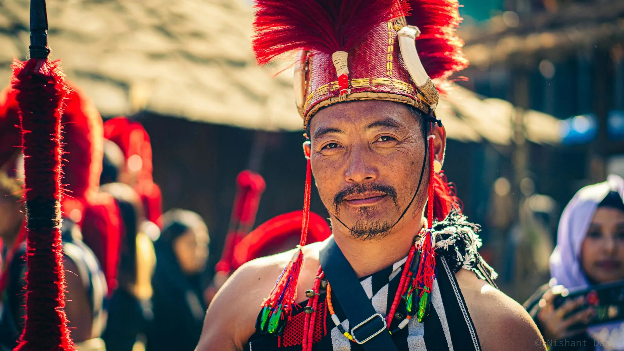 A Naga man in a red feathered headdress