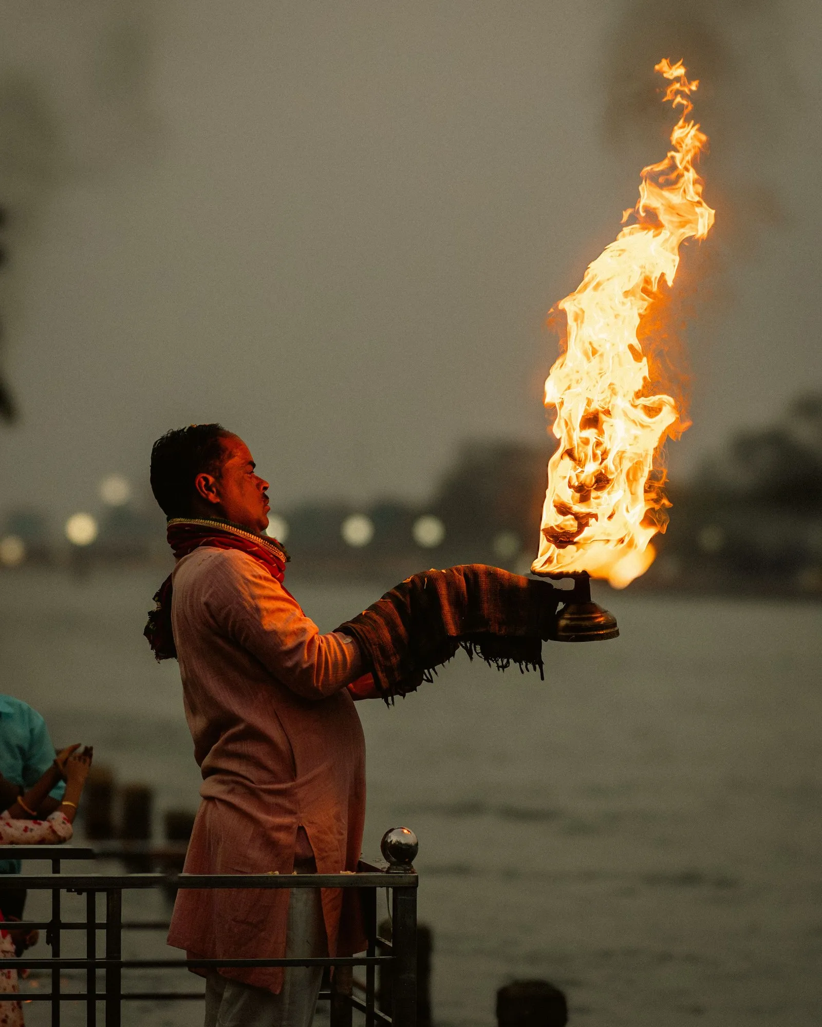 A man raising a fire lamp at the evening aarti on the Ganga, Rishikesh