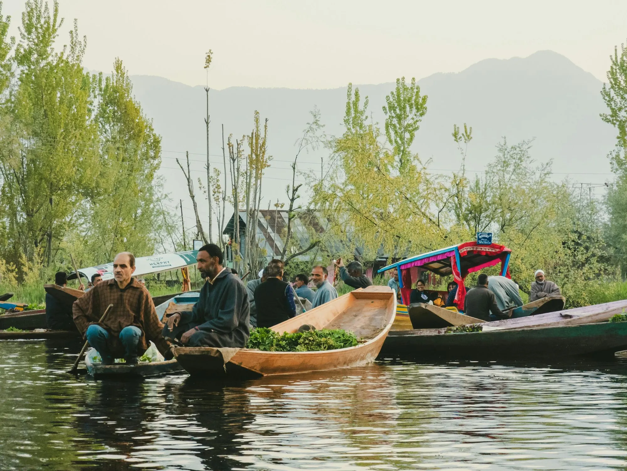 Boatmen trading vegetables from shikaras at the floating market on Dal Lake